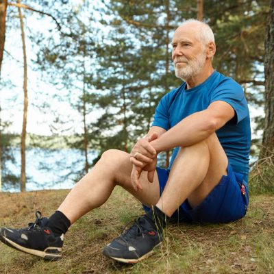 Handsome thoughtful elderly man in stylish sports clothes sittin