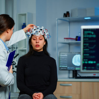 Neurological doctor cheking eeg headset explaining treatment